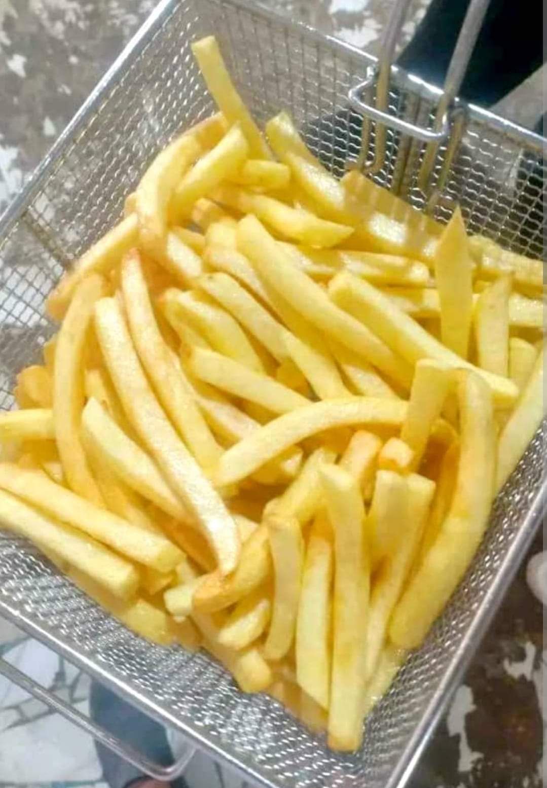 Golden French fries in a frying basket