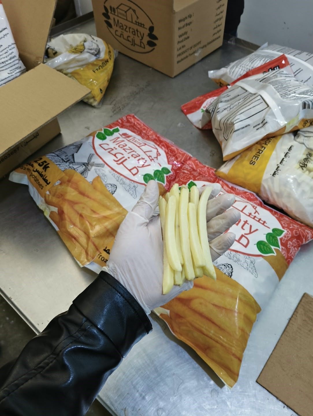 Checking frozen French fries next to Mazraty bags in the packing area