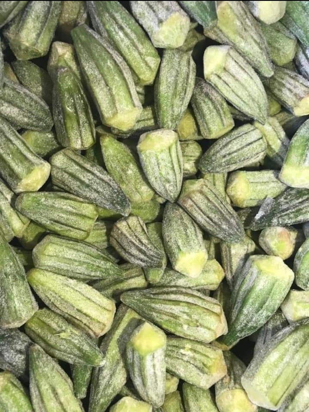 Whole frozen okra pods with a light frost, ready for packing
